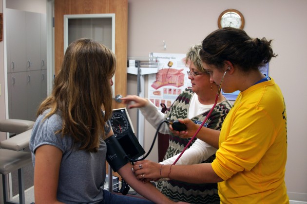 Leah Siegel 14 learning how to check blood pressure from Dawn Chlipala RN, Chelsea Momany 11.  Photo Credit: Brandon Fennell