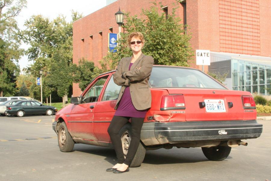  Roberta Davidson, professor of English, stands outside the 1987 Chevy Nova she drives to work. Although Davidson lives close to campus, she drives because she brings books and a laptop to work and often goes on errands at the end of the day. Photo Credit: Isabel Hong