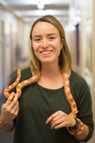 Senior Eva Geisse handles Candy the corn snake. Photo by Henry Honzel.