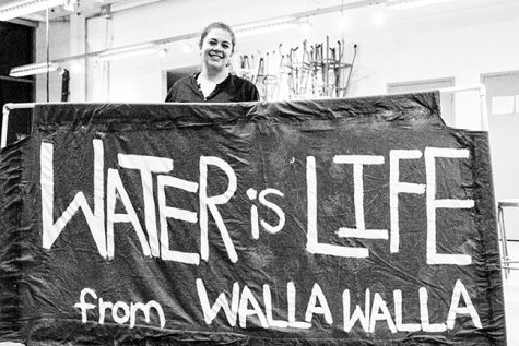 Senior Maddie Bailey poses with a poster that Rapp, Law, Lee, Kitzerow and Woodall are bringing to the Standing Rock protest. 